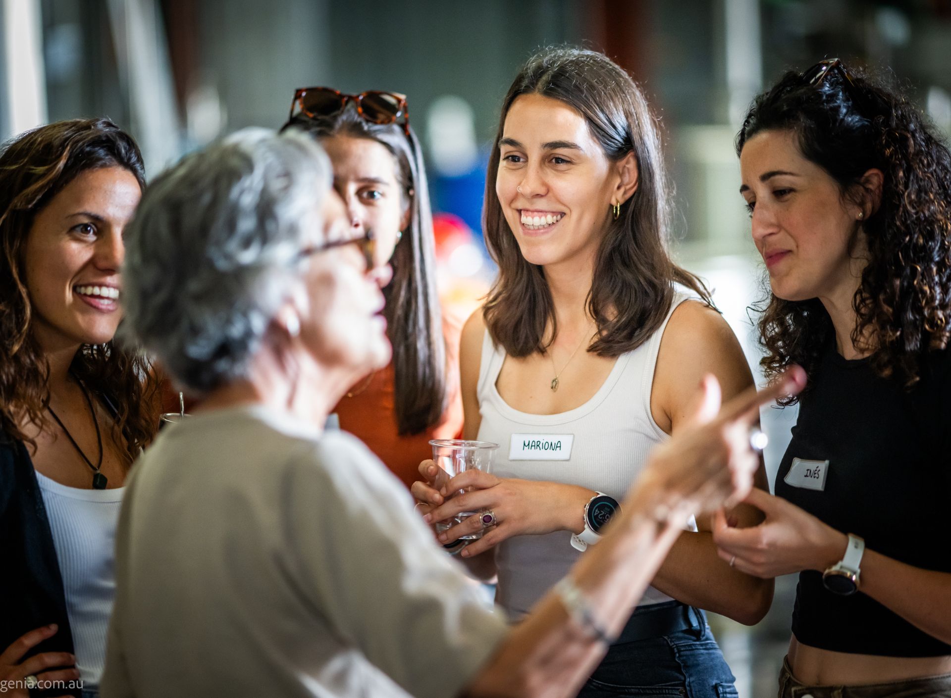 Quatre noies parlant amb una dona durant l'esdeveniment de la Castanyada 2025 del Casal Catala de Queensland a Brisbane